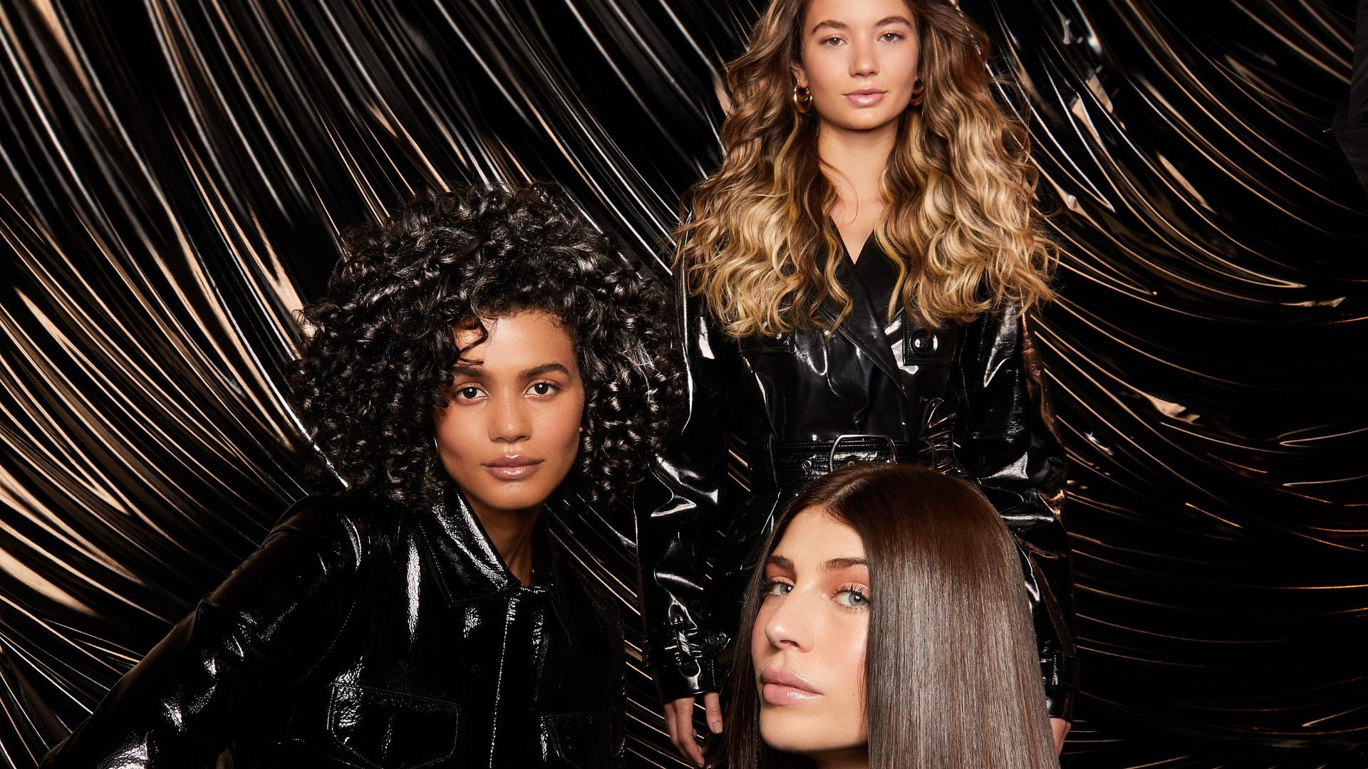 Tres mujeres con cabello brillante: una rubia con ondas, una con rizos oscuros, una con cabello oscuro con brillo extremo. La imagen es un anuncio de Brillo Lamelar de TRESemmé.